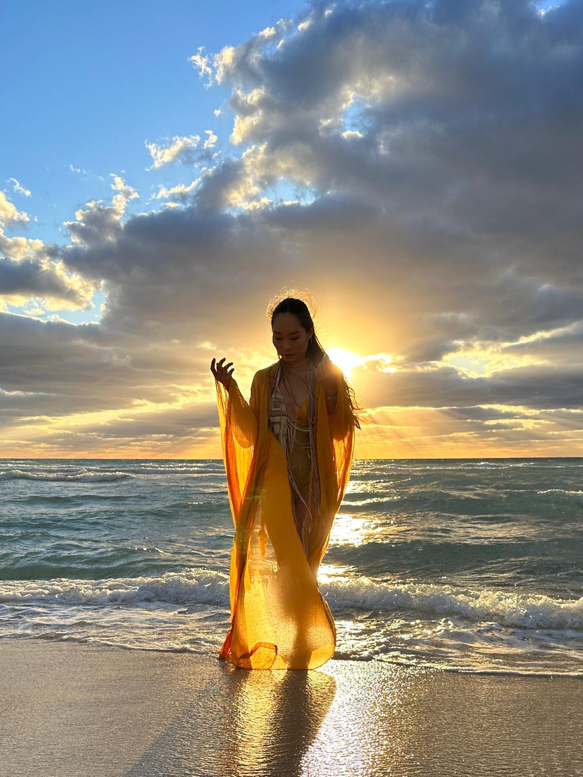 Model in a golden caftan on Miami Beach at sunset